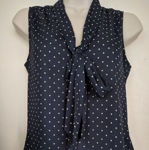 Sleeveless navy white polka dot shirt.